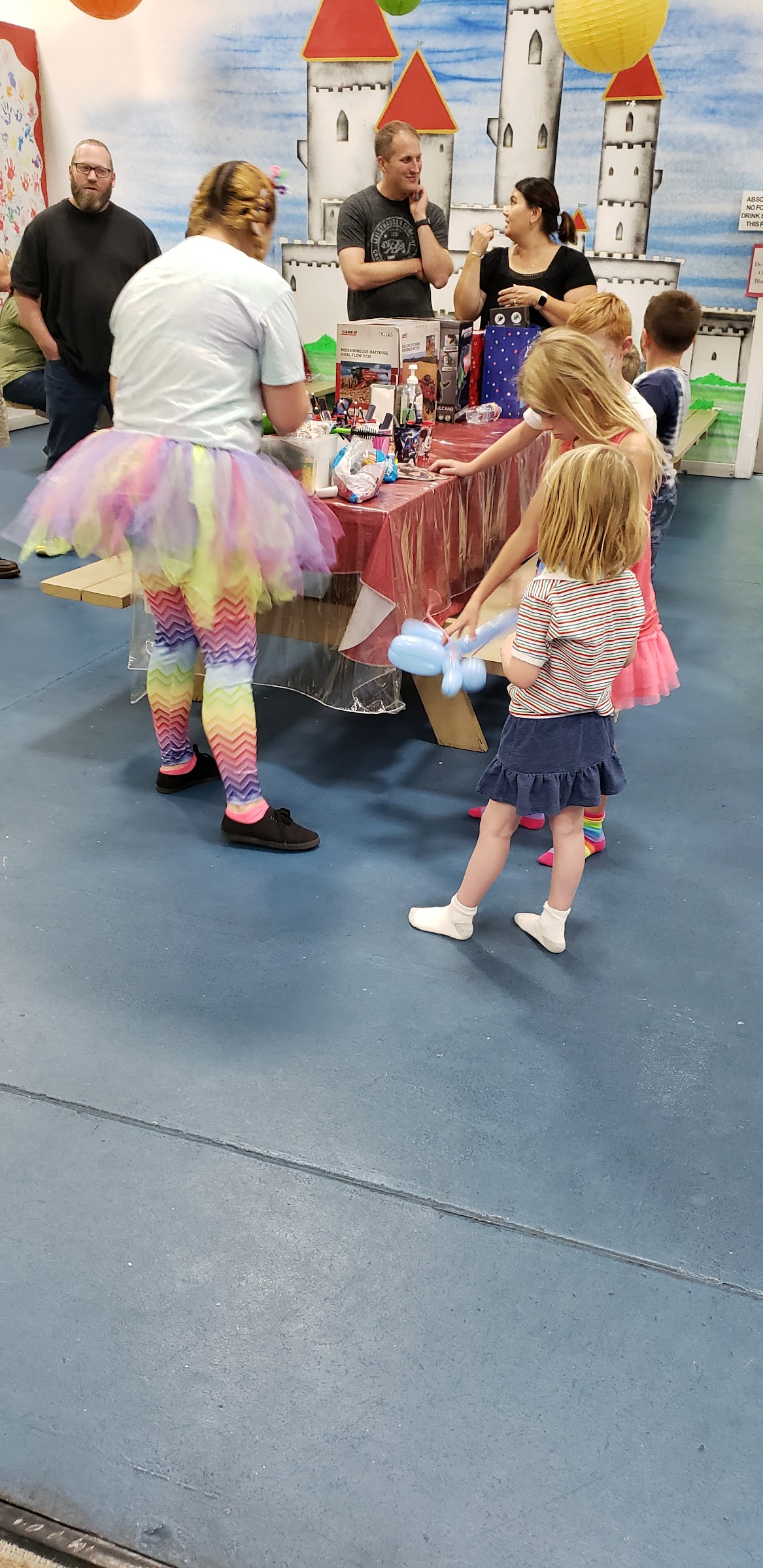 A costumed balloon-twisting party entertainer at Inflatable Fun Gym, with kids and parents gathered around